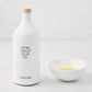 Hudson Grace white ceramic olive oil bottle with wood cork and a matching dipping bowl with oil.