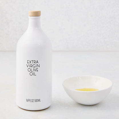 Hudson Grace white ceramic olive oil bottle with wood cork and a matching dipping bowl with oil.