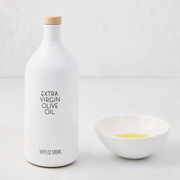 Hudson Grace white ceramic olive oil bottle with wood cork and a matching dipping bowl with oil.