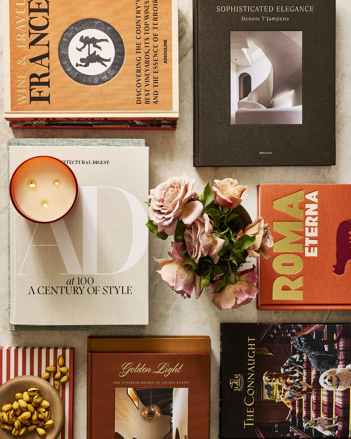 Hudson Grace coffee table books on art, interior design, food, and travel styled with flowers and an HG original candle