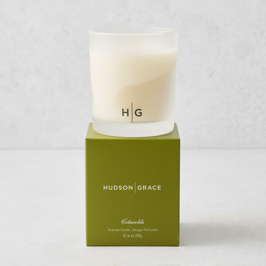 Hudson Grace Cotswolds scented candle in a frosted glass vessel atop a green branded gift box.