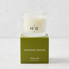 Hudson Grace Cotswolds scented votive candle in a frosted glass vessel resting on a green branded gift box.
