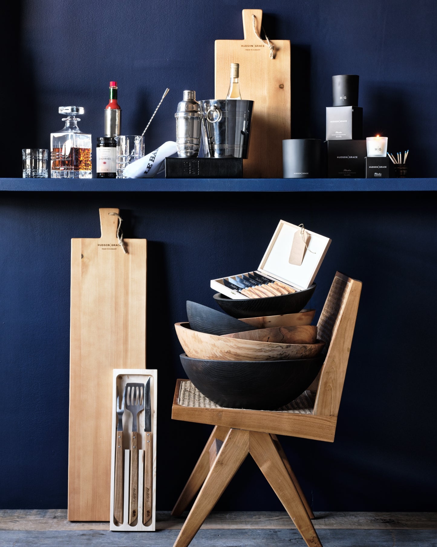Hudson Grace Father's Day gifts including wooden cutting boards, bowls, and kitchen utensils on a dark blue background.
