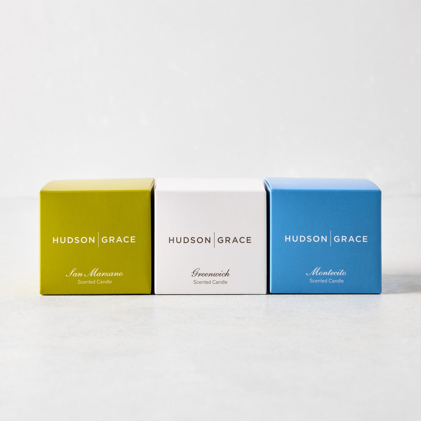 Hudson Grace Fresh Scented Votive Gift Set: three small square boxes in lime green, white, and blue.