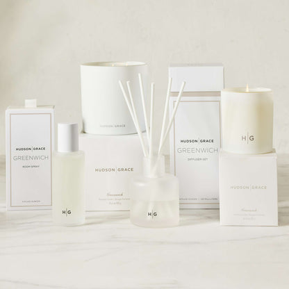 Hudson Grace Greenwich white 3-wick candle, room spray, and diffuser set on a marble surface.