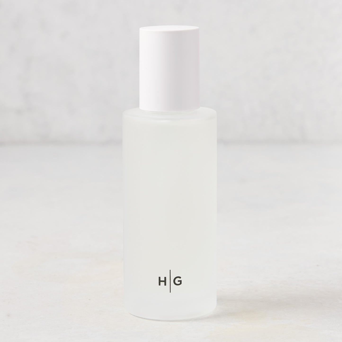 Hudson Grace Greenwich Scented Room Spray: 5.08 oz frosted glass bottle with white cap and HG logo.