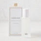 Hudson Grace Greenwich Room Spray: frosted glass bottle, white cap, next to white box with gold ribbon.