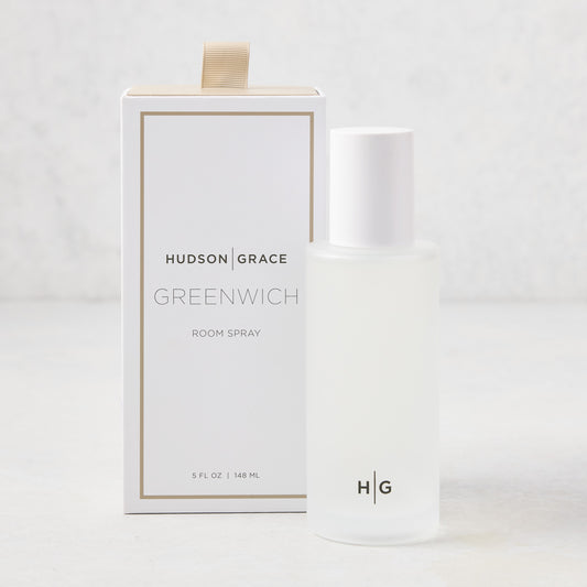 Hudson Grace Greenwich Room Spray: frosted glass bottle, white cap, next to white box with gold ribbon.