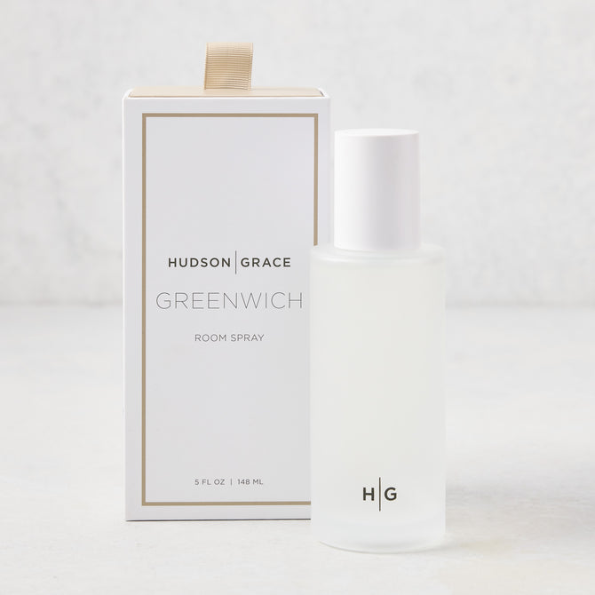 Hudson Grace Greenwich Room Spray: frosted glass bottle, white cap, next to white box with gold ribbon.