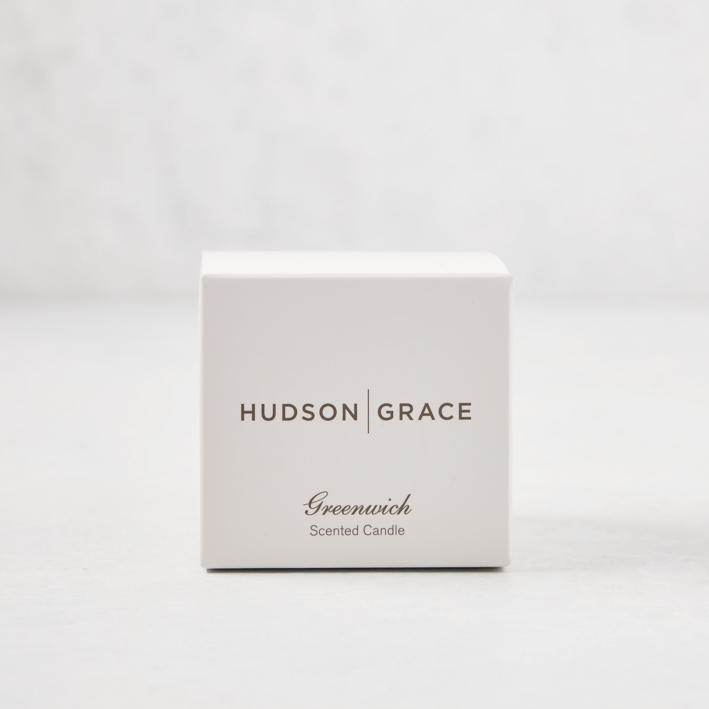 Hudson Grace Greenwich Scented Votive candle in a white gift box with brown text.