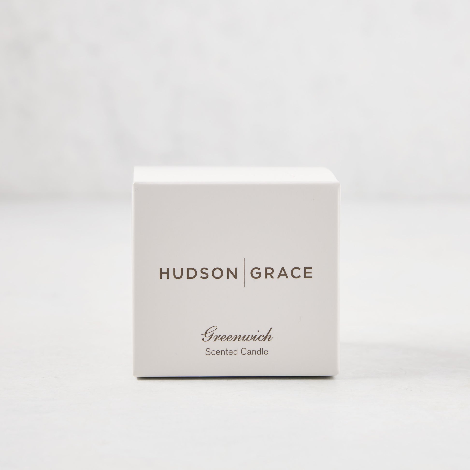 Hudson Grace Greenwich Scented Votive candle in a white gift box with brown text.