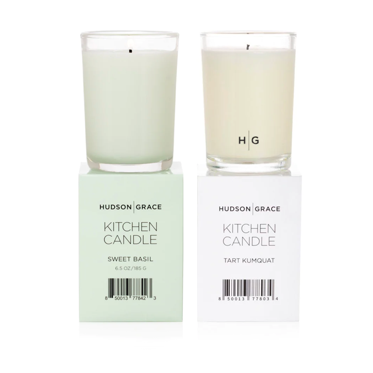 Hudson Grace Kitchen Candle Bundle: two glass candles, one light green Basil, one cream Tart Kumquat, on their boxes.