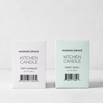 Hudson Grace Kitchen Candle Bundle: white Tart Kumquat and light green Sweet Basil candles in elegant boxes.