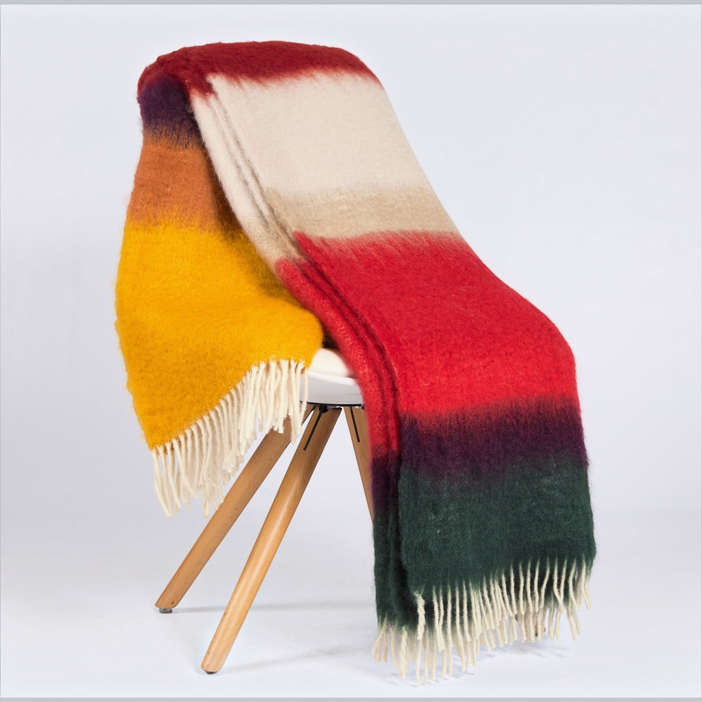 Hudson Grace Mantas Ezcara Matisse mohair throw blanket featuring vibrant red, yellow, and green stripes with fringe.