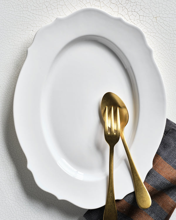 Hudson Grace Modern Lungarno white oval serving platter with scalloped edges and brass serving utensils