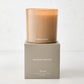 Hudson Grace Montauk 3-wick scented candle in a translucent amber glass vessel, on its gray gift box.
