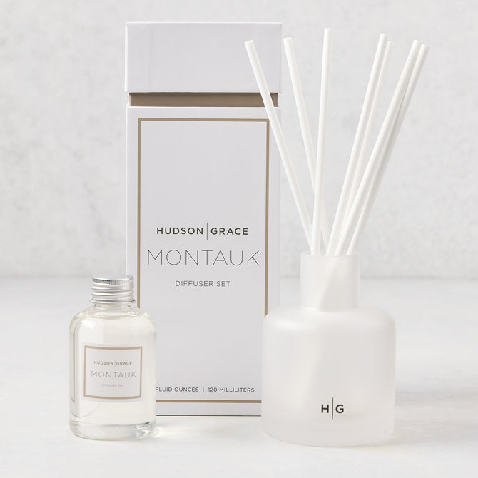 Hudson Grace Montauk Scented Reed Diffuser set: clear glass bottle, frosted glass vessel with white reeds, and white box.