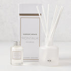 Hudson Grace Montauk Scented Reed Diffuser set: clear glass bottle, frosted glass vessel with white reeds, and white box.
