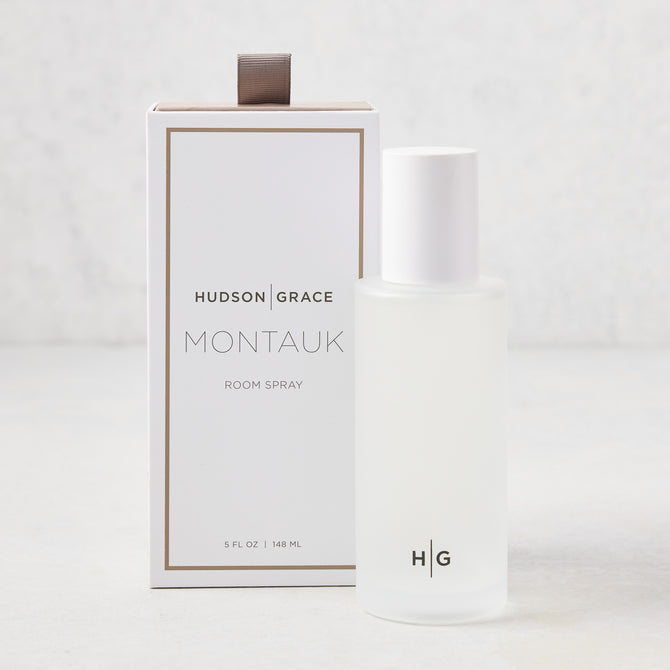 Hudson Grace Montauk 5.08 oz frosted glass room spray bottle with white cap next to its white and gold box.