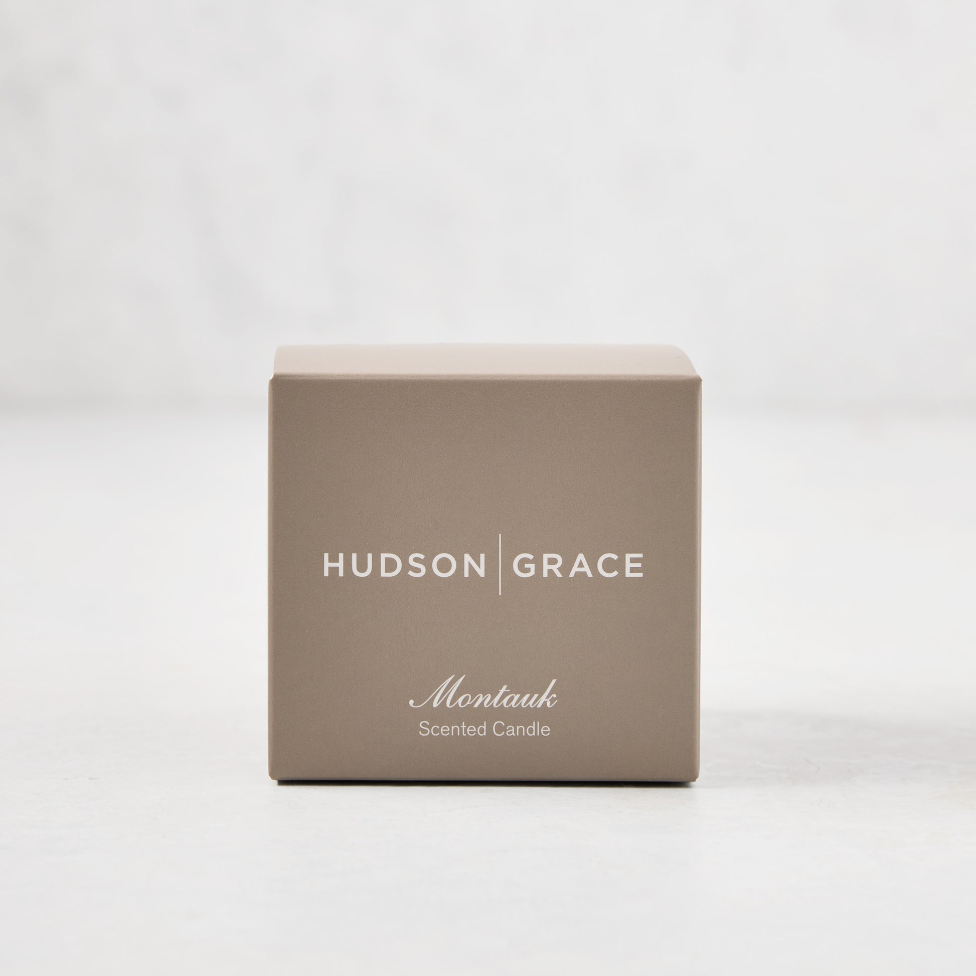 Hudson Grace Montauk Scented Votive candle in a light brown box with white text.