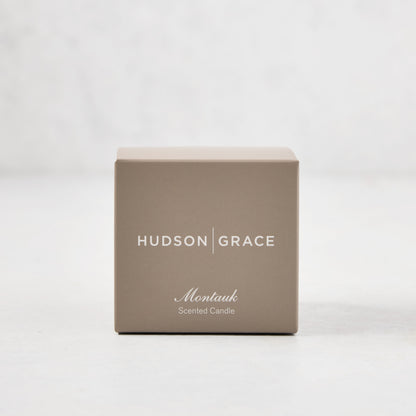 Hudson Grace Montauk Scented Votive candle in a light brown box with white text.