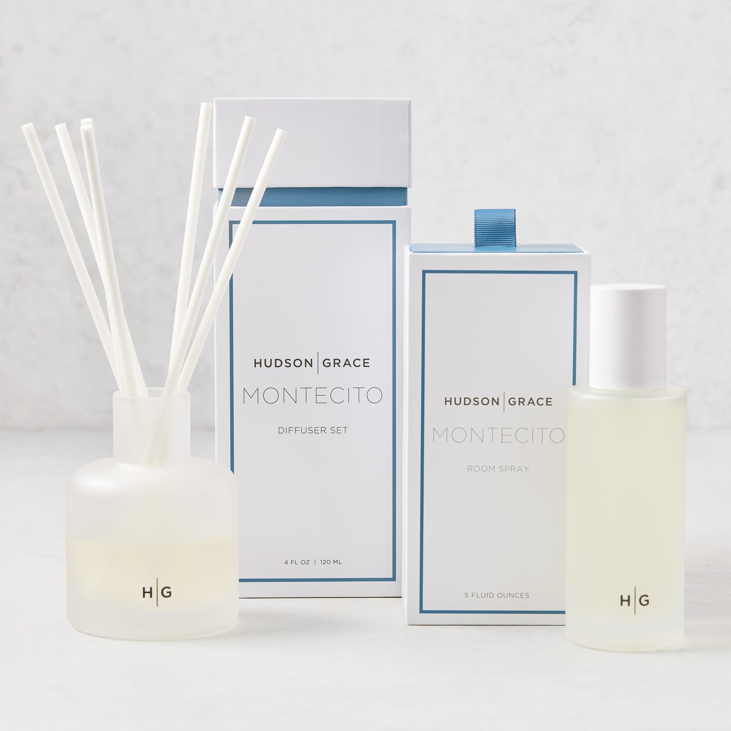 Hudson Grace Montecito Room Spray and Diffuser Gift Set: frosted glass bottles, white boxes with blue accents.