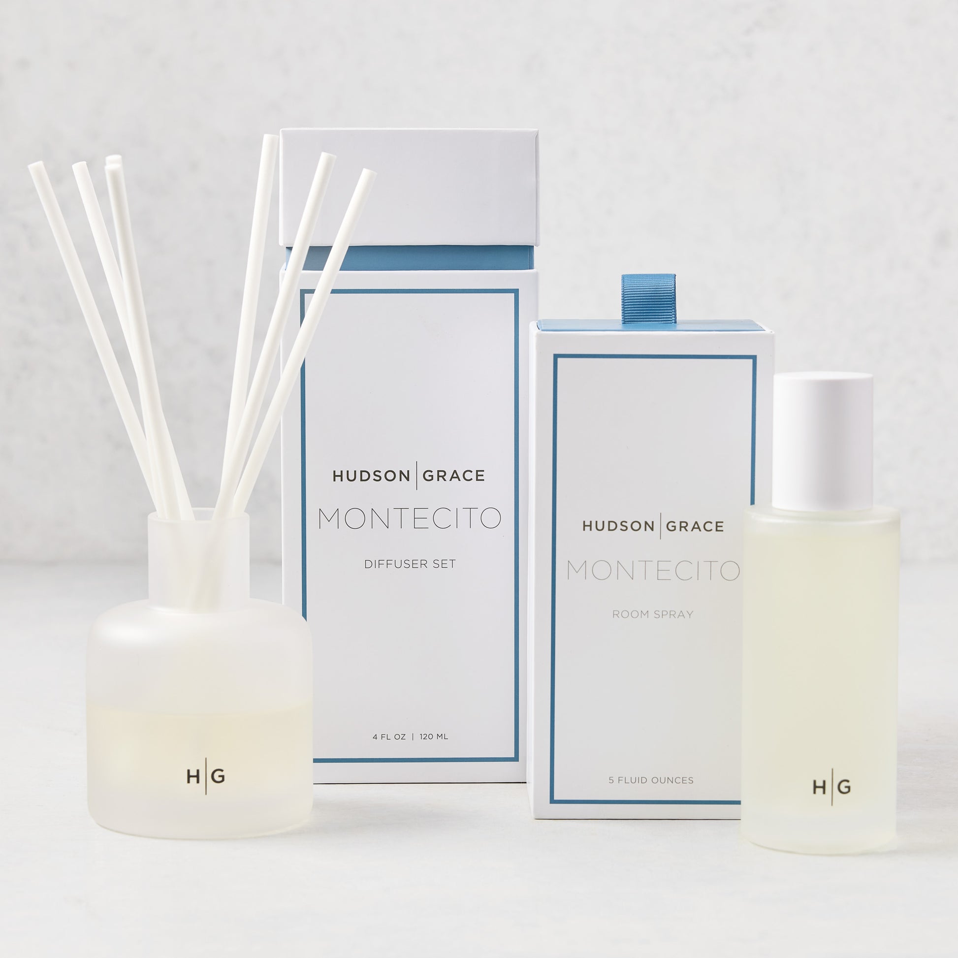 Hudson Grace Montecito Room Spray and Diffuser Gift Set: frosted glass bottles, white boxes with blue accents.