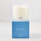 Hudson Grace Montecito 3-wick candle in a frosted glass vessel with HG logo, on a blue gift box.