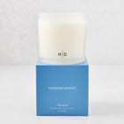 Hudson Grace Montecito 3-wick candle in a frosted glass vessel with HG logo, on a blue gift box.