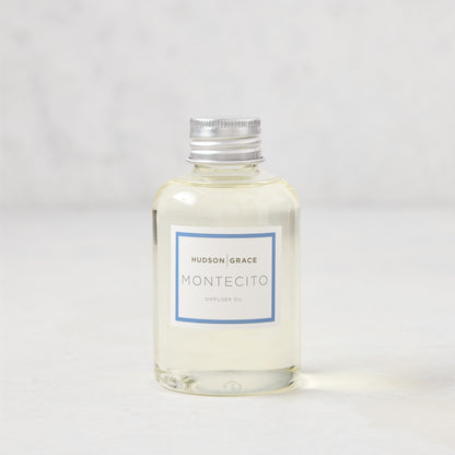 Hudson Grace Montecito 4oz clear glass diffuser oil refill bottle with silver cap and blue label.