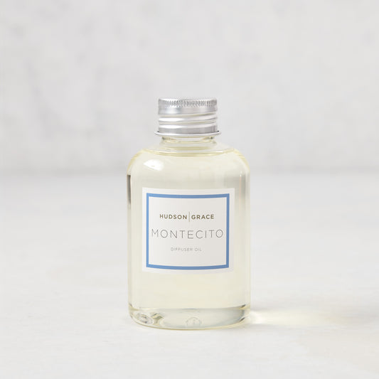 Hudson Grace Montecito 4oz clear glass diffuser oil refill bottle with silver cap and blue label.
