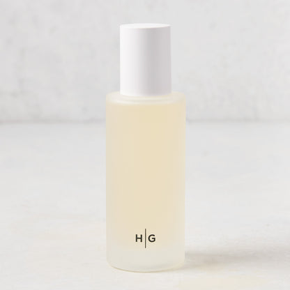 Hudson Grace Montecito scented room spray in a frosted glass bottle with white cap and "HG" logo.