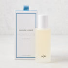 Hudson Grace Montecito 5 oz room spray in a frosted glass bottle with white cap, beside its white and blue box.