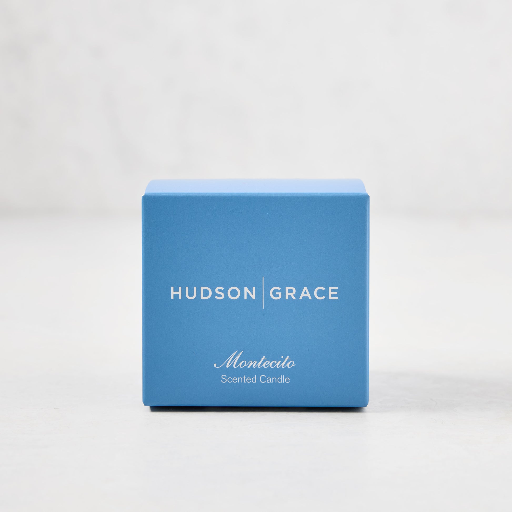 Hudson Grace Montecito Scented Votive in a blue gift box with white text.