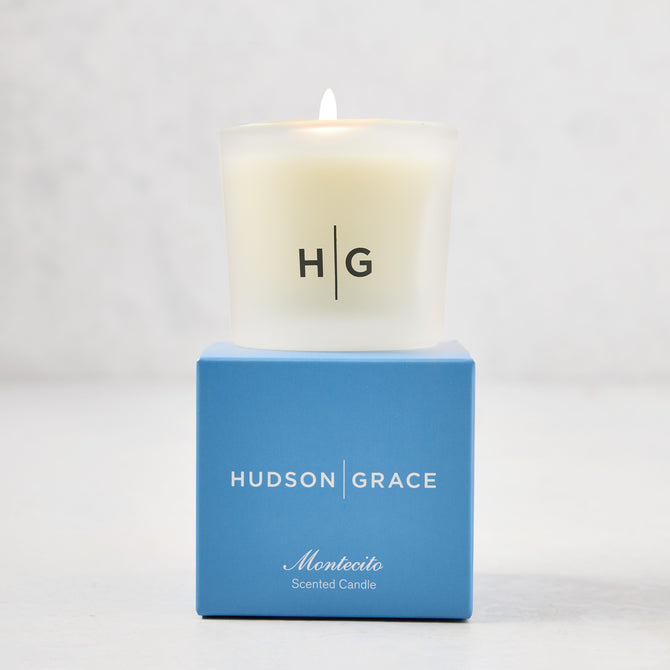 Hudson Grace Montecito scented votive candle in a frosted glass vessel with a blue box.