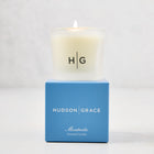 Hudson Grace Montecito scented votive candle in a frosted glass vessel with a blue box.