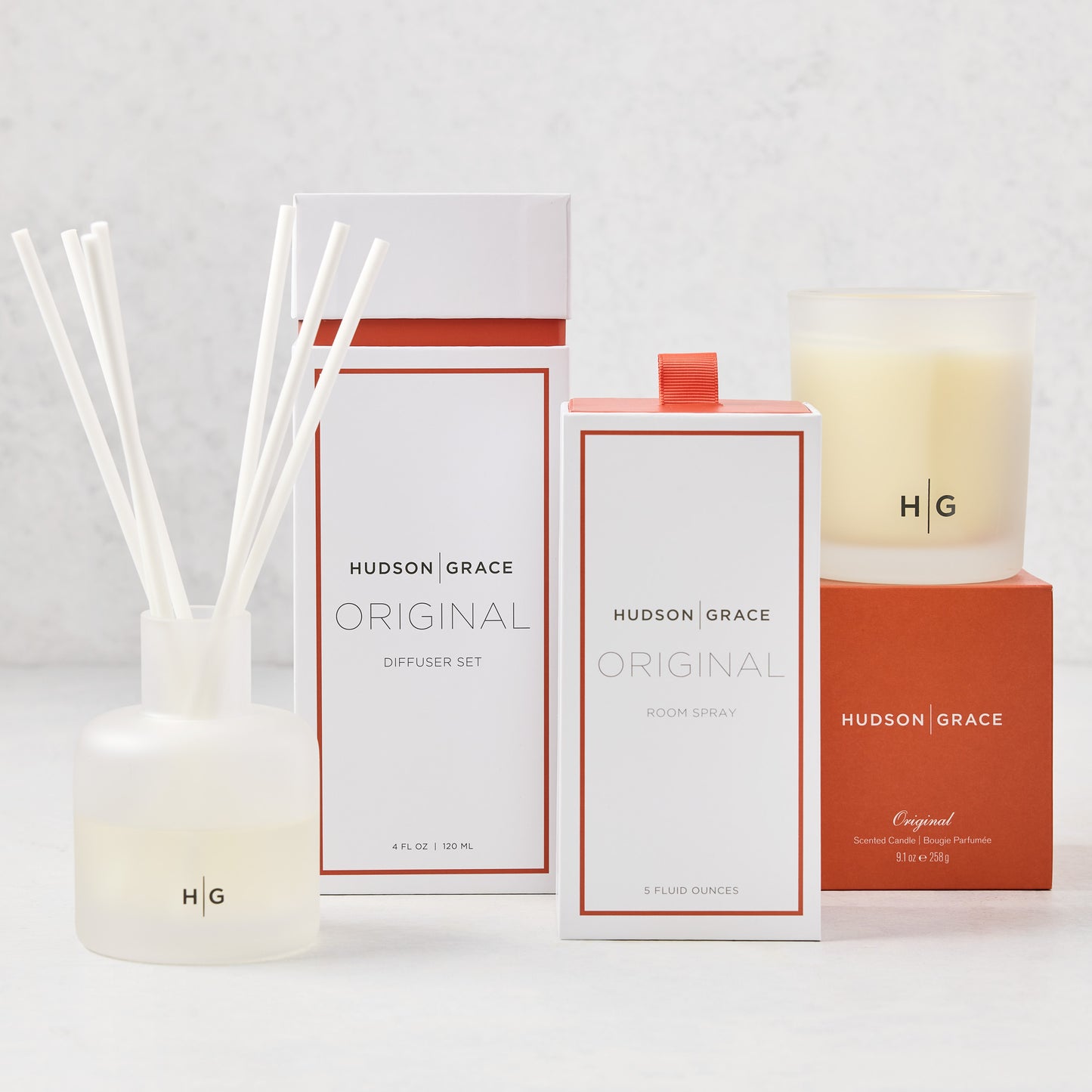 Hudson Grace Original Scent Gift Set: white diffuser, room spray, and candle with orange accents.
