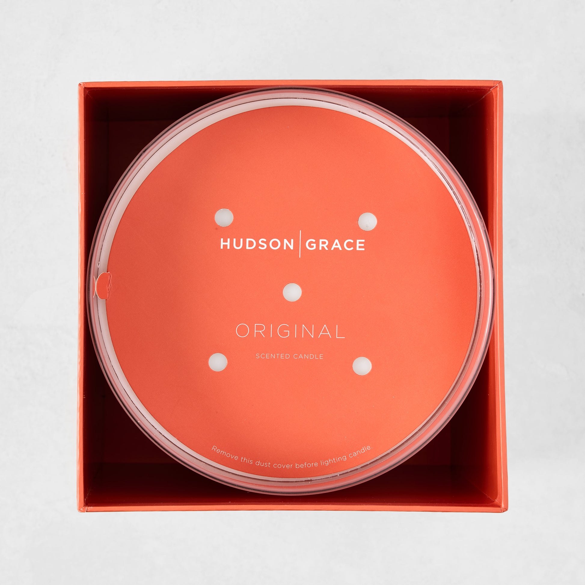 Hudson Grace Original Scented 4-Wick Candle in an orange box, with a clear lid and orange dust cover.