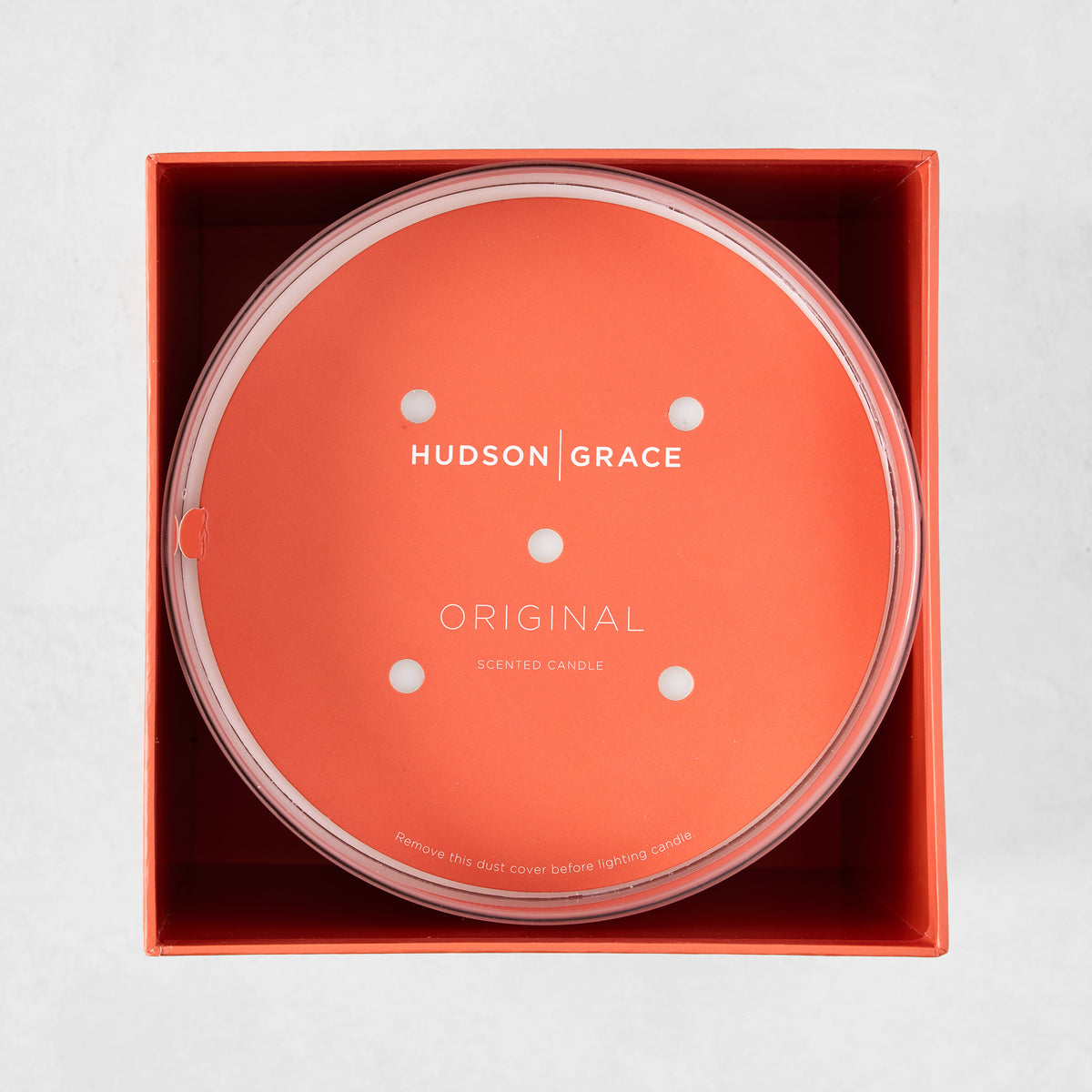 Hudson Grace Original Scented 4-Wick Candle in an orange box, with a clear lid and orange dust cover.