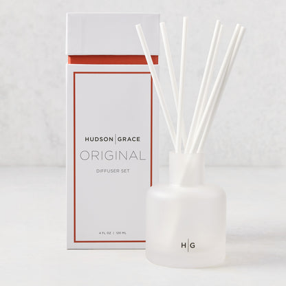 Hudson Grace Original Scented Diffuser set with frosted glass vessel, white reeds, and white box with orange accent.