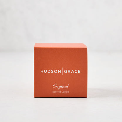 Hudson Grace Original Scented Votive Candle in an orange box with white text.