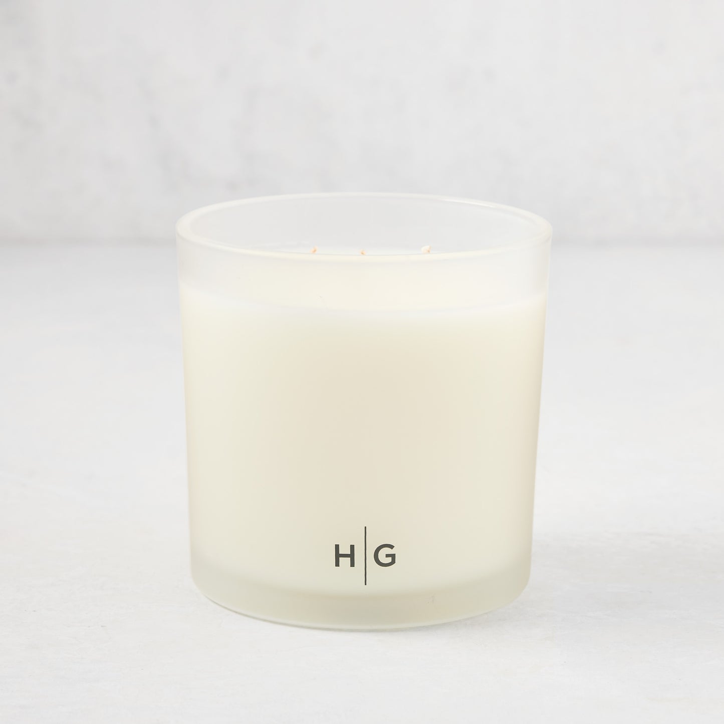 Hudson Grace Palm Beach 3-wick candle in a frosted glass vessel with "HG" logo.