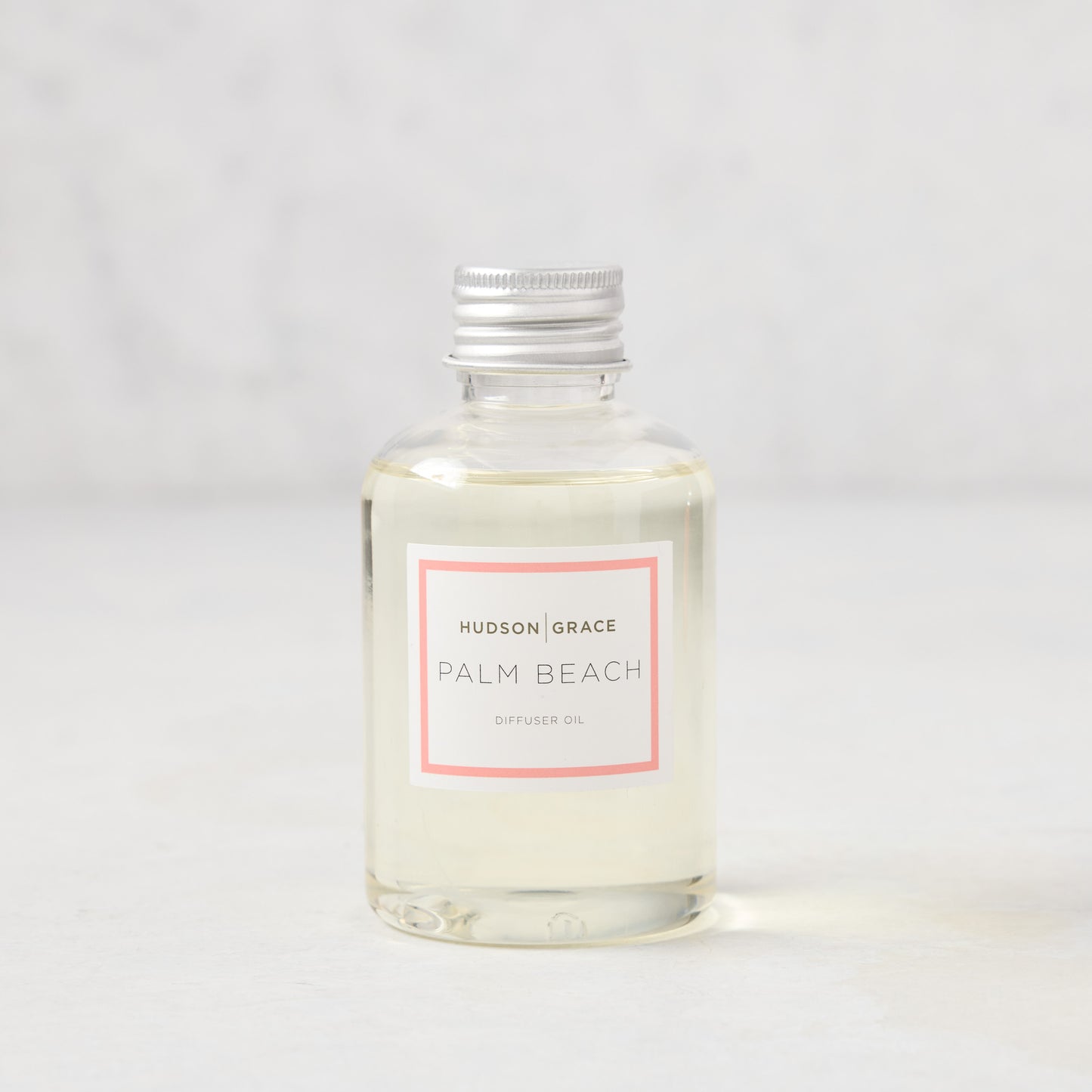 Hudson Grace Palm Beach scented diffuser oil refill, clear glass bottle with silver cap and pink label.
