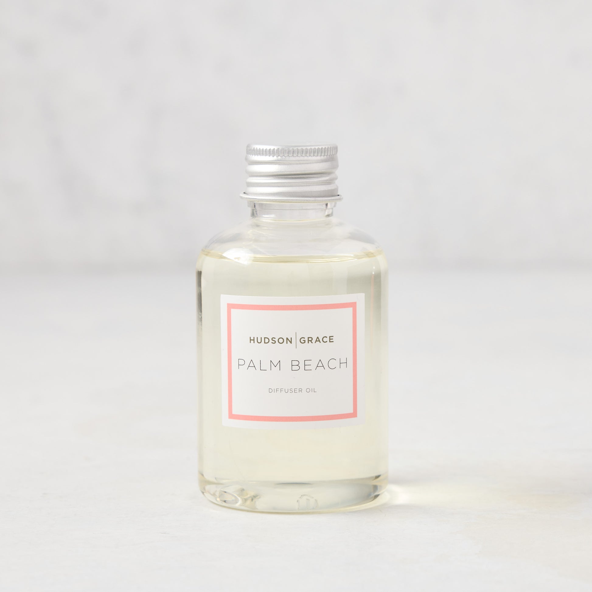 Hudson Grace Palm Beach scented diffuser oil refill, clear glass bottle with silver cap and pink label.