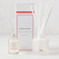 Hudson Grace Palm Beach reed diffuser set with frosted glass vessel, white reeds, and oil bottle.