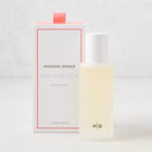 Hudson Grace Palm Beach Room Spray, 5 oz, in a frosted glass bottle with a white cap, next to its white and coral box.