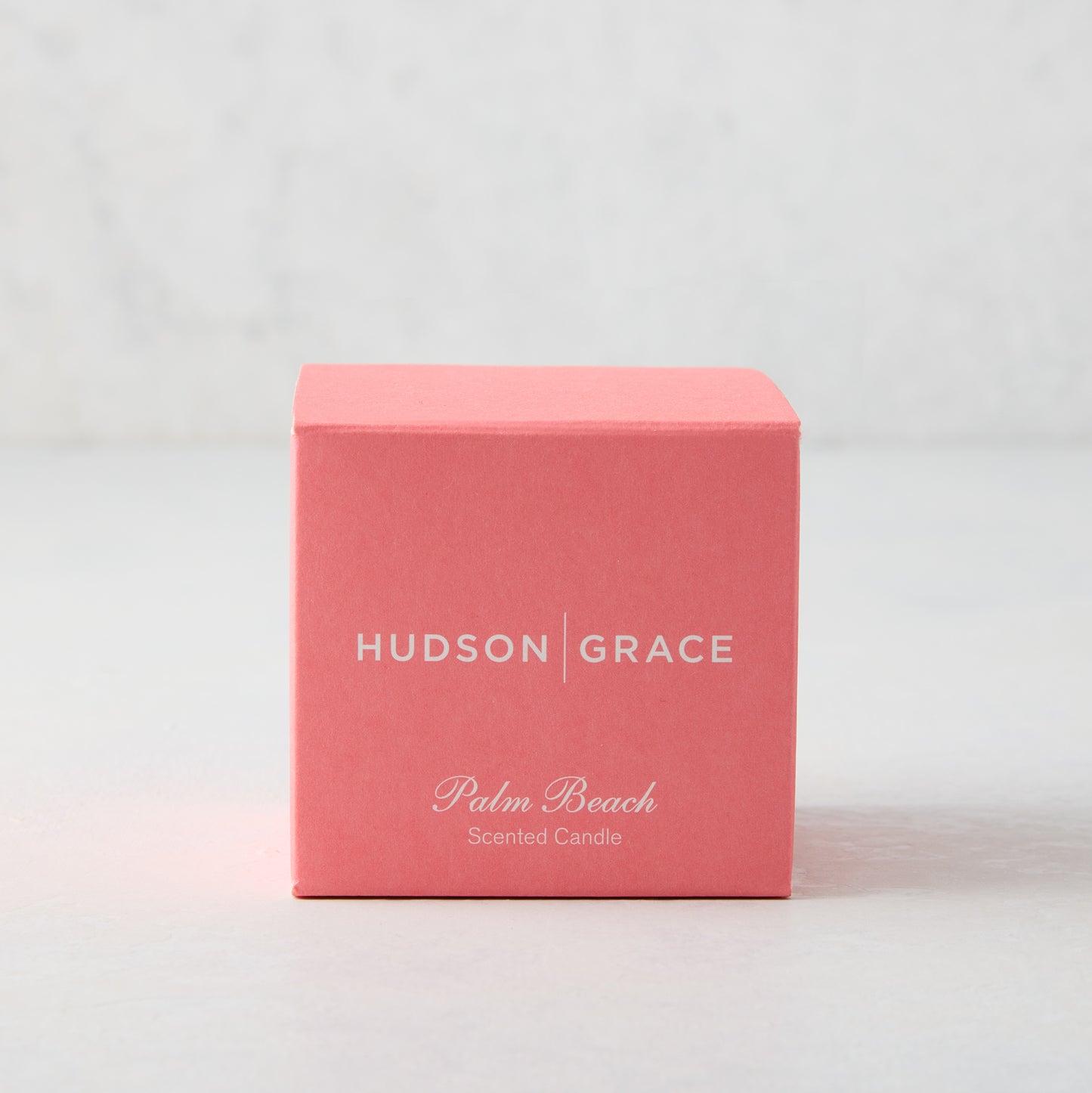 Hudson Grace Palm Beach Scented Votive Candle in a coral pink box with white text.