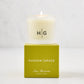 Hudson Grace San Marzano Votive candle in a frosted glass vessel with "HG" logo, atop a green box.