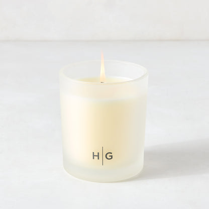 Hudson Grace Savannah scented candle in a frosted glass vessel with a lit wick.
