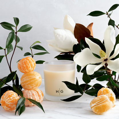 Hudson Grace Savannah scented candle in a frosted glass vessel with magnolia flowers and peeled mandarins.